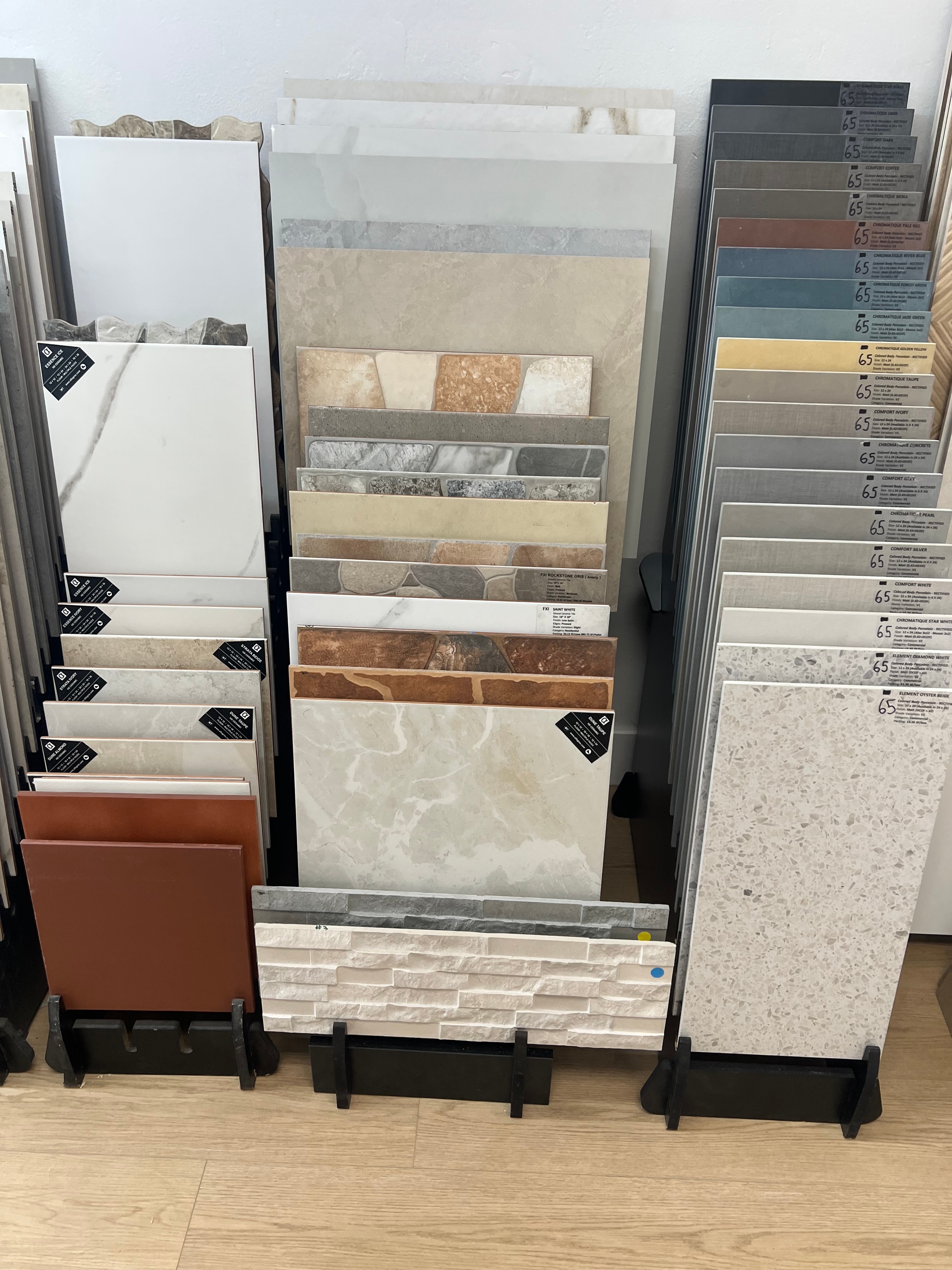 Rack del showroom con amplia selección de muestras de piso para patio en tonos neutros, tierra y gris