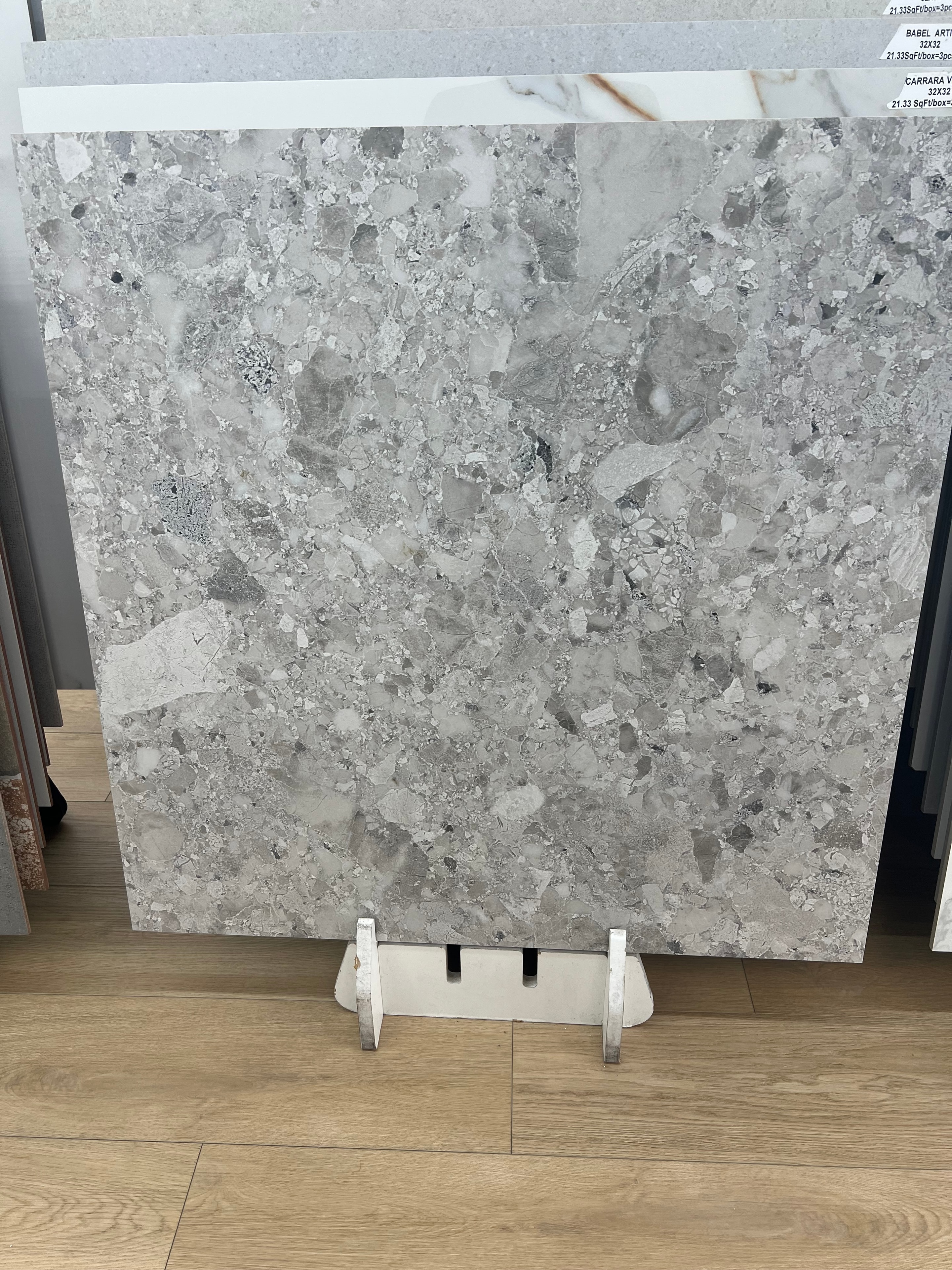 Carrara-style terrazzo porcelain tile with gray and white aggregate texture